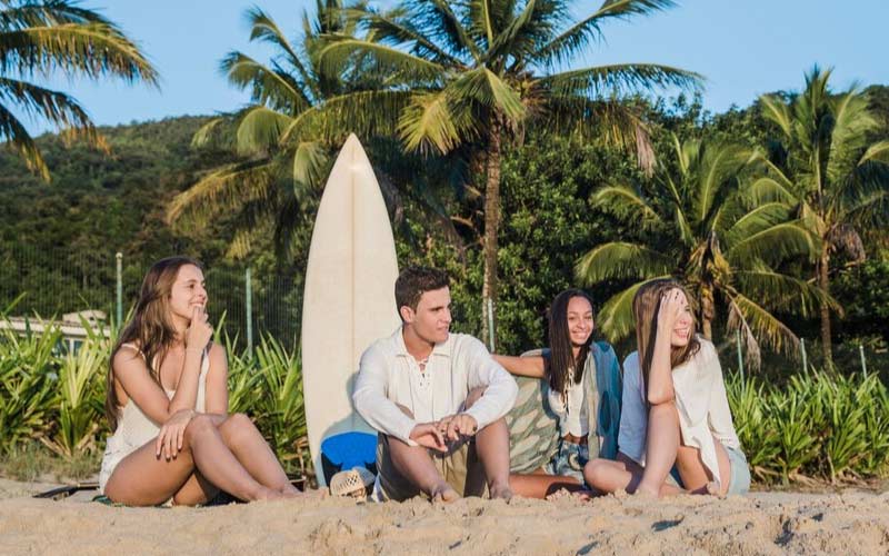 group of friends posing together by the beach, comfortable coach charter, August 2024, Australia